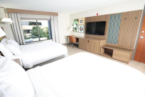 a hotel room with a bed and a tv at Holiday Inn Saint Louis-Fairview Heights by IHG in Fairview Heights