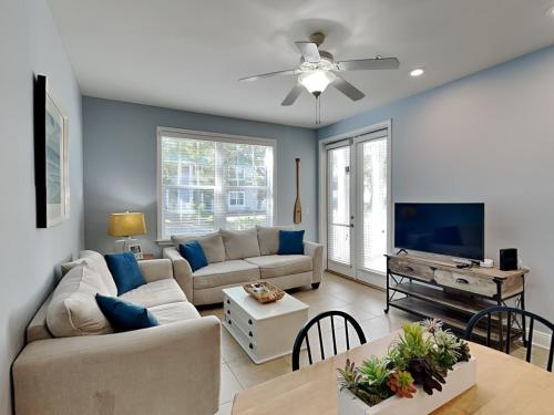 a living room with a couch and a tv at The Village #514 in Blue Mountain Beach