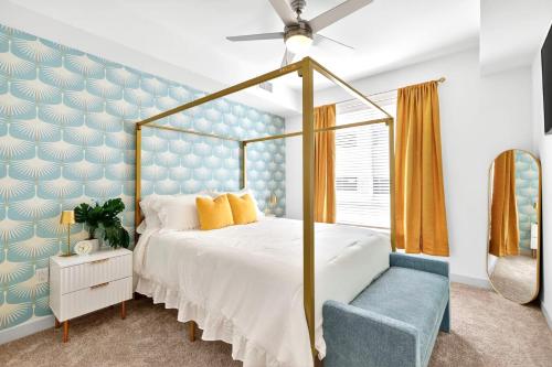 ジャクソンビルにある2 BR suite with game room & amenitiesの青い壁のベッドルーム1室(天蓋付きベッド1台付)