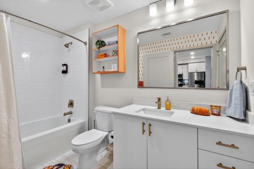 ジャクソンビルにある2 BR suite with game room & amenitiesの白いバスルーム(洗面台、トイレ、鏡付)