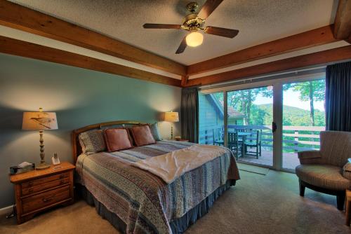 Un dormitorio con una cama con ventilador de techo y una ventana. en Penrith Hideaway at Yonahlossee, en Boone