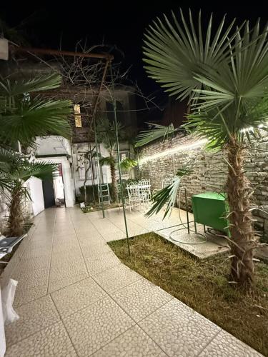 a courtyard with a palm tree next to a building at The Journey Inn in Shkodër