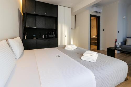 a bedroom with a large white bed with towels on it at Triple A - Athena Collection - Heart of Athens - Near Famous Mokka Coffee- FREE Parking! in Athens
