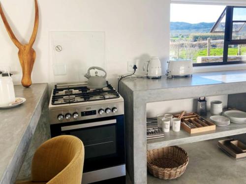 a kitchen with a stove and a counter with a table at Aardvark Bioreserve in Ladismith