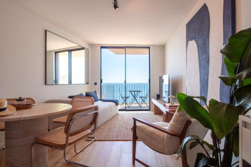 a living room with a bed and a table and chairs at EDiTiON 309 - Luxury Seafront 2BR Apartments in Porto