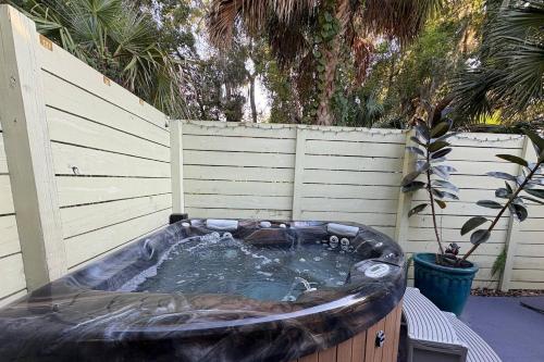 a hot tub in a backyard with a fence at Little Blue Cottage in St. Augustine
