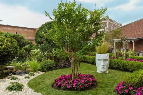 a tree in the middle of a garden with flowers at Berkeley Oceanfront Hotel in Asbury Park