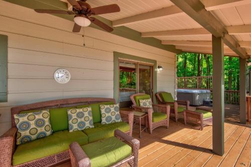 a screened porch with a green couch and chairs at 1 Sublime View in Boone