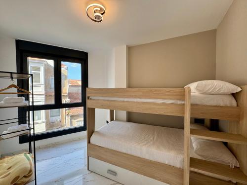 Una pequeña habitación con literas y una ventana. en Cíes Premium Suitel Ponte 9 - Love your Stay, en Marín