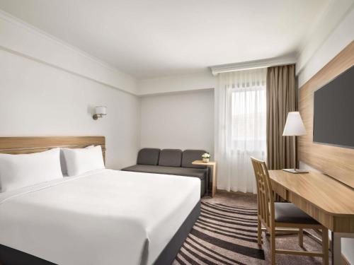 a hotel room with a bed and a desk at Novotel Cairo Airport in Cairo