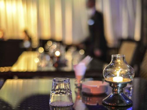 a candle and a glass jar on a table at Novotel Cairo Airport in Cairo