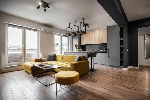 a living room with a yellow couch and a table at Skylark - Toronto Penthouse with Jacuzzi & Mountain View in Braşov