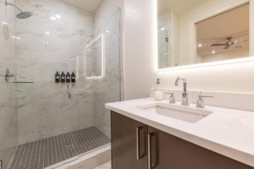 a white bathroom with a sink and a shower at The Theodore New Orleans in New Orleans