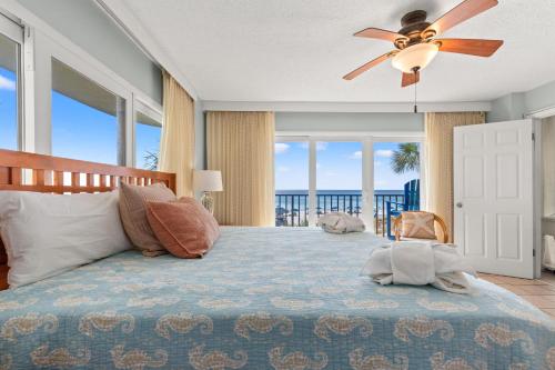 a bedroom with a bed with a ceiling fan at Commodore 0201 in Panama City Beach