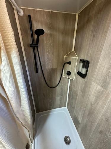 a bathroom with a shower with a sink and a toilet at הקרוואן במושב in Beʼerotayim