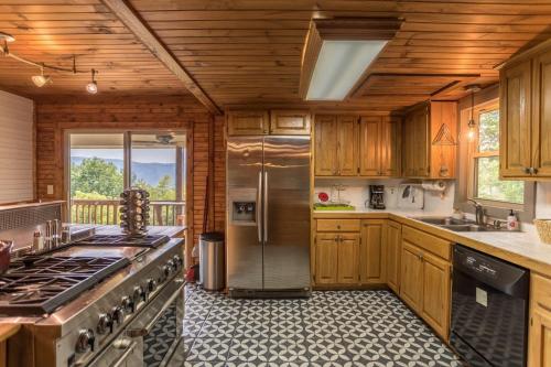 a kitchen with wooden cabinets and a stainless steel refrigerator at Grandview Getaway in Boone
