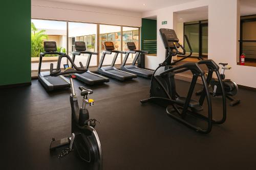 a gym with several treadmills and elliptical machines at Holiday Inn Tulum by IHG in Tulum