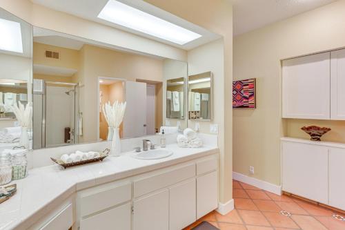 a bathroom with two sinks and a large mirror at Golf Course View and Pool Access Palm Desert Condo in Palm Desert Country