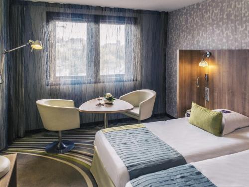a hotel room with a bed and a table at Mercure Angers Centre de Congrès in Angers