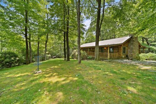 a log cabin in the woods with a yard at Natures Call in Boone