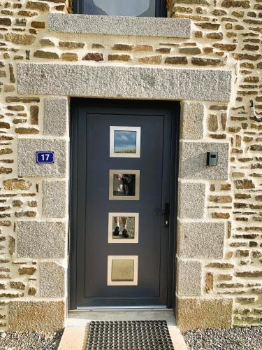 a blue door in a stone wall with pictures on it at Le gîte du Plessis in Montanel