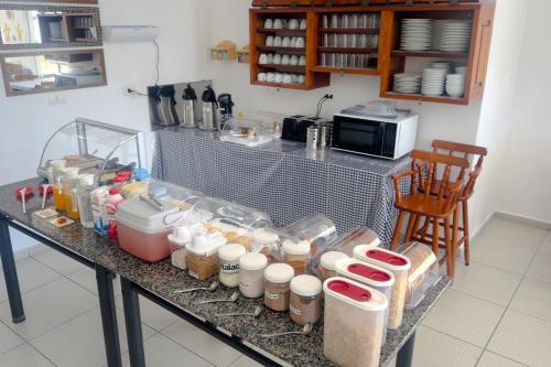 a counter in a kitchen filled with lots of food at VELINN Hotel Guarda Mor in São Sebastião