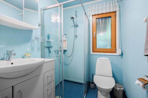 a blue bathroom with a toilet and a shower at VAS109-Kalv-Roesarp-Sperlingsholm-203 in Kalv