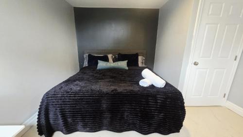 a bedroom with a large bed with a black blanket at Lakefront House 25 minutes from downtown Ottawa-Gatineau in Gatineau