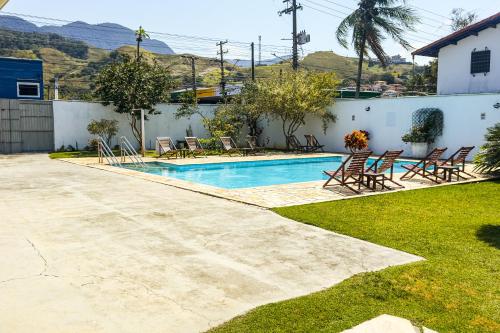 a swimming pool in a yard with chairs around it at VELINN Hotel Guarda Mor in São Sebastião