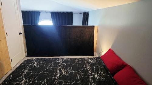 a small bedroom with a bed and a red pillow at Lakefront House 25 minutes from downtown Ottawa-Gatineau in Gatineau