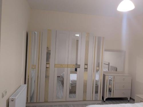a bedroom with a large mirror and a dresser at Parkside Residences in Tbilisi City