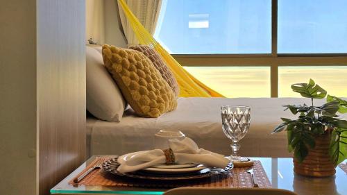 a room with a bed with a table with a glass at DVA Cabedelo by Hosppedar in Cabedelo