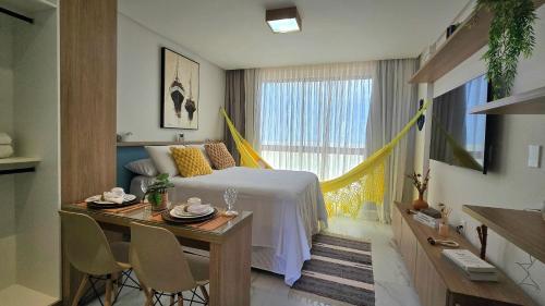 a hotel room with a bed and a table and chairs at DVA Cabedelo by Hosppedar in Cabedelo