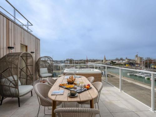 a table and chairs on a balcony with a view at Mercure La Rochelle Vieux Port in La Rochelle
