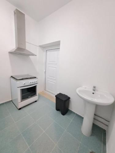 a white kitchen with a sink and a stove at Espaço Rural in Juncal