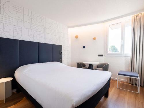 a bedroom with a large white bed and a window at ibis Beziers Est Mediterranee A9/A75 in Béziers