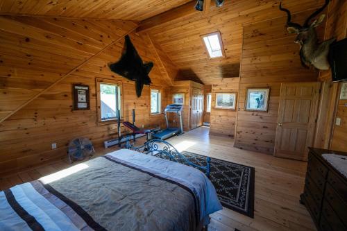 Un dormitorio con una cama en una cabaña de troncos en 5BR Luxurious Mountain Escape, en Forksville