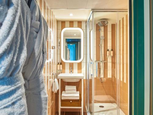 a bathroom with a sink and a shower at Mercure Paris Butte Montmartre Basilique in Paris