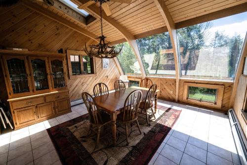 comedor con mesa y sillas en una cabaña en 5BR Luxurious Mountain Escape, en Forksville