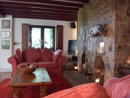 ein Wohnzimmer mit einem roten Sofa und einer Steinmauer in der Unterkunft Sardis Cottage in Stepaside