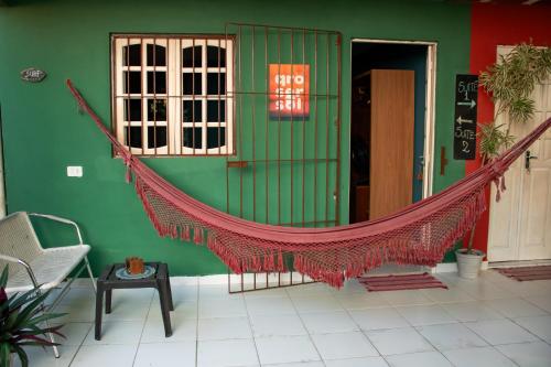 a hammock in front of a green building at Serrambi Praia Suites in Porto De Galinhas