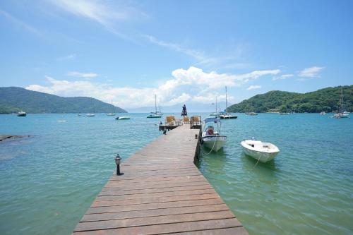 a dock with two boats on a body of water at CASA DA ILHA INN AND SPA Anexo1 in Angra dos Reis
