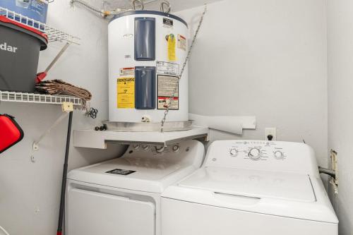 Un pequeño lavadero con lavadora y secadora. en Peaceful 2Bd 2Bth Pondside Condo - MaryEtta, en Melbourne