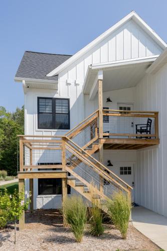 a large white house with a deck and stairs at Bay Pointe Inn in Orangeville