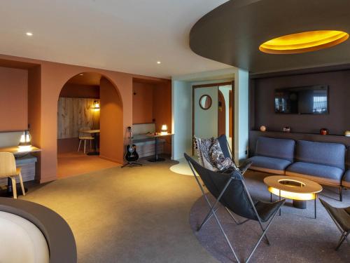 a living room with a blue couch and chairs at IBIS STYLES Rouen Parc Expos Zenith in Saint-Étienne-du-Rouvray