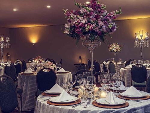 ジョインヴィレにあるMercure Joinville Prinzの紫花瓶のテーブル