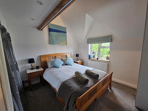 バイブリーにあるImperfect home in perfect location, Bibury hot tubの大きなベッドと2つの枕がある寝室