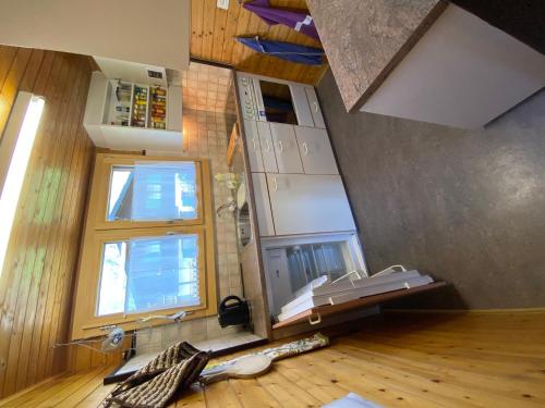 a room with a kitchen with a floor and two windows at Chalet Oase in Susten