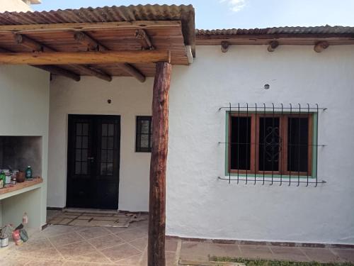 a white house with a black door and a window at Alojamiento Madariaga 224 in Goya