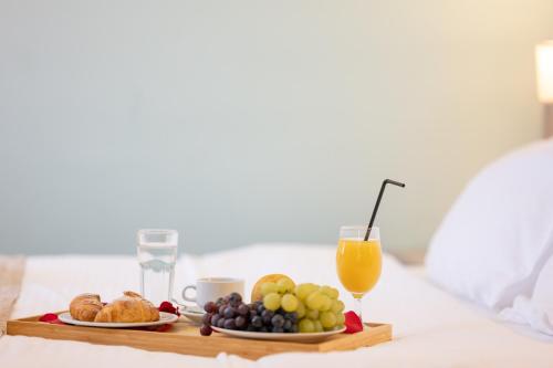 a breakfast tray with fruit and a glass of orange juice at Kopernikus Hotel Prag in Belgrade